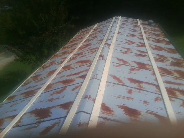 Rusted metal roof panels with new wood purlins before replacement — Storm Damage Roof Repair in Danciger by Roofing Brothers