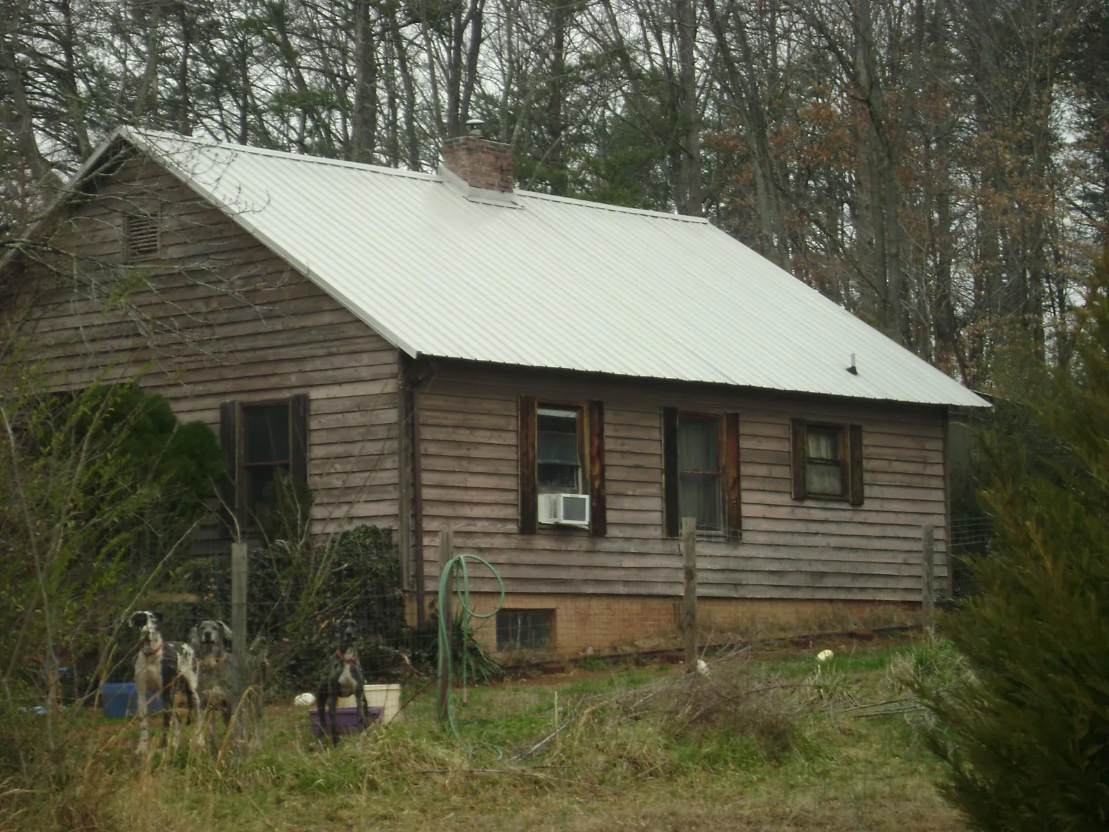 White metal roof on an old wood sided farmhouse, from a Metal Roof Installation job in Danciger